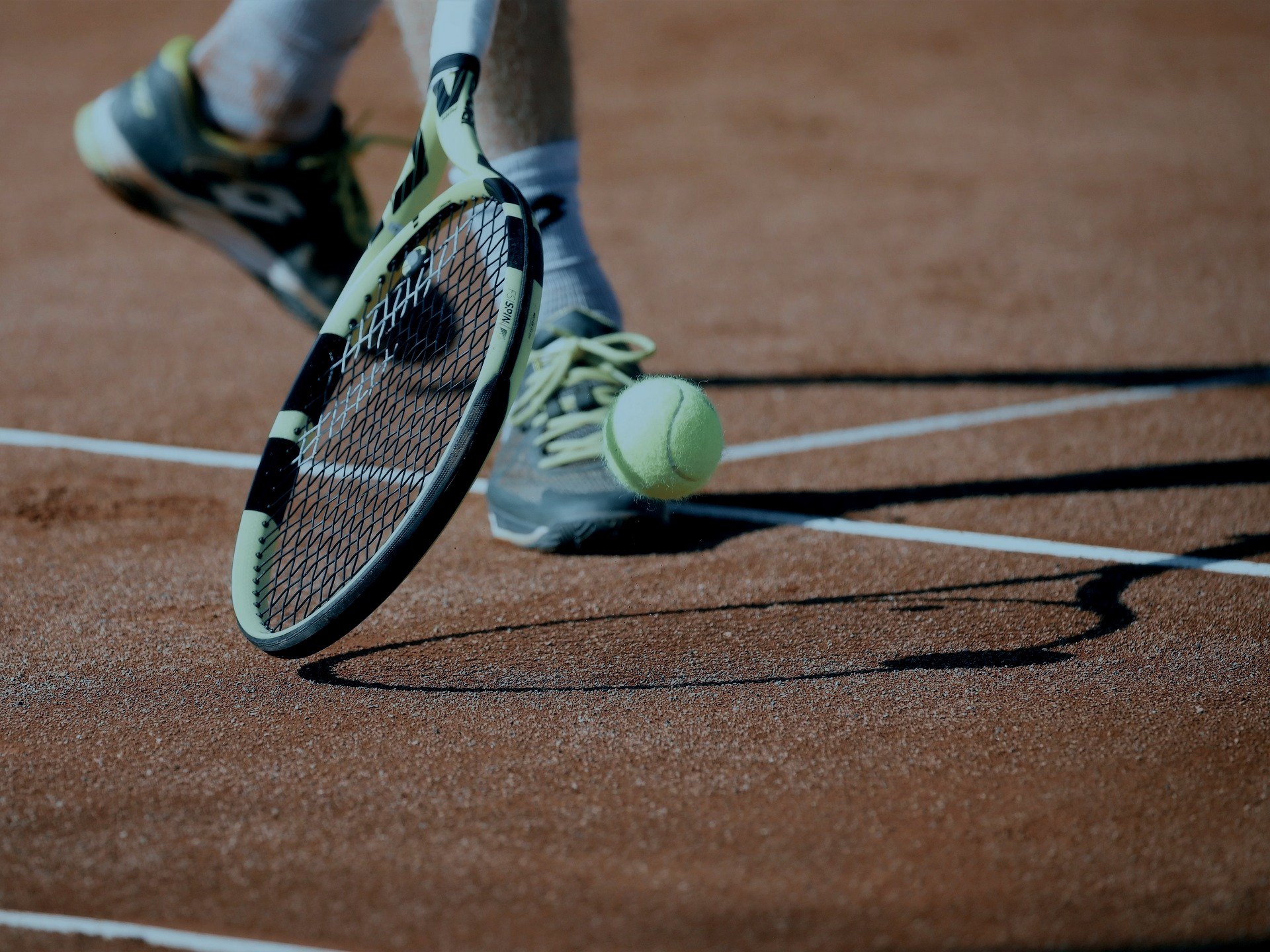 Tennisschläger und Bälle auf einem Sandplatz